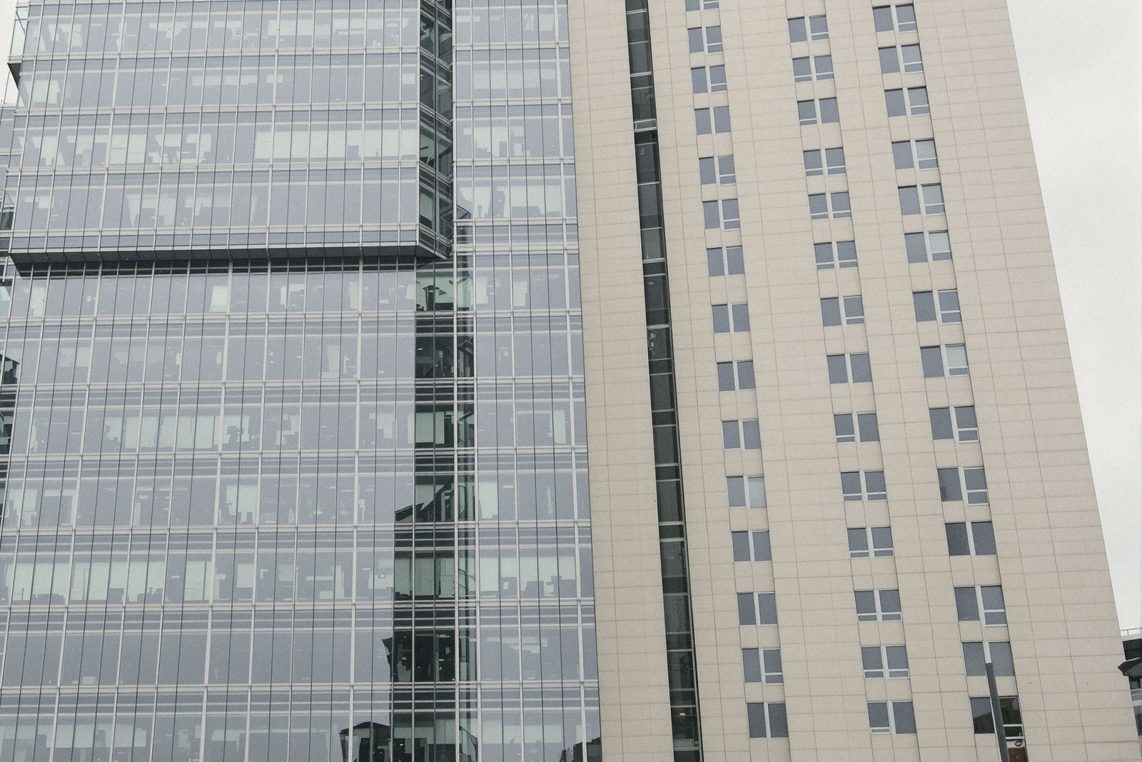 Tours de bureaux vitrées du quartier de La Défense sous un ciel gris